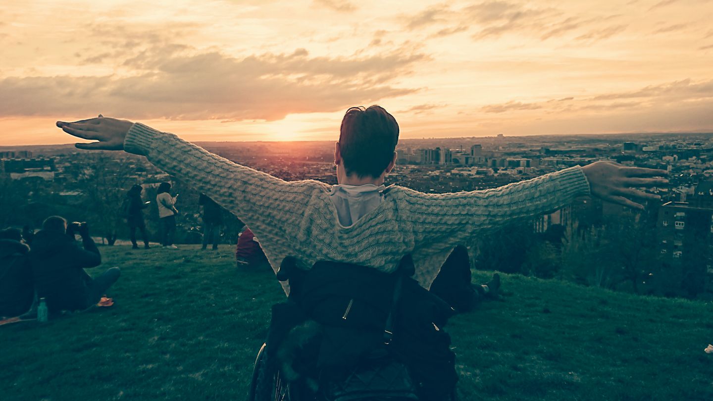 Anna viendo el atardecer desde una colina con los brazos extendidos (como sensación de libertad)